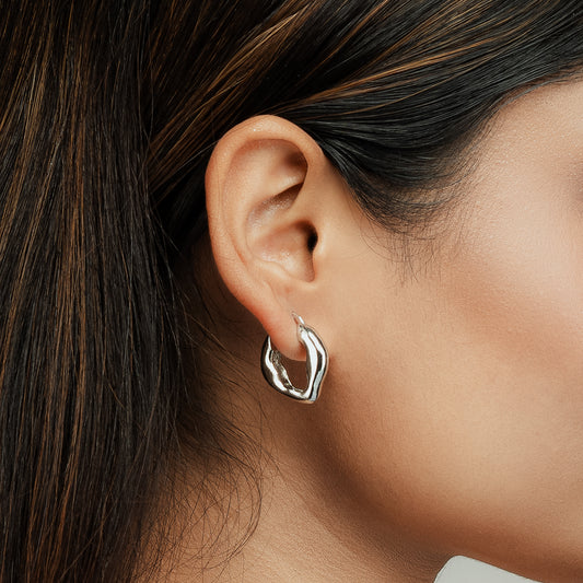 Model showcasing Gulban’s signature Dazzle Hoop earring in silver, a refined 18k gold plated demi fine jewellery piece known for its unique organic silhouette and lightweight comfort, ideal for everyday glamour