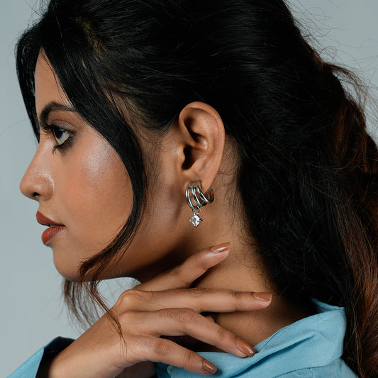 Side profile of a woman wearing Gulban’s Hyperbola Silver Hoop Earring, a statement dual hoop earring with solitaire charm in 18K gold plated finish. Elegant demi fine jewellery styled for modern sophistication.