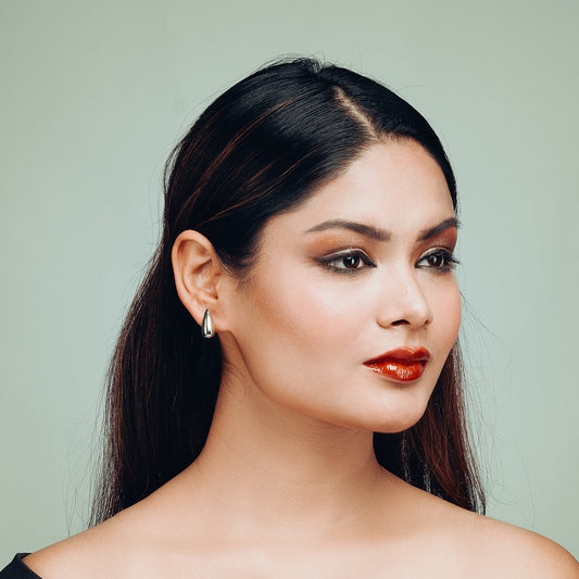 Front-facing model wearing Tearlight Drop earrings by Gulban, featuring polished silver teardrop earrings in a minimalist demi fine jewellery style, ideal for Gen Z fashion.