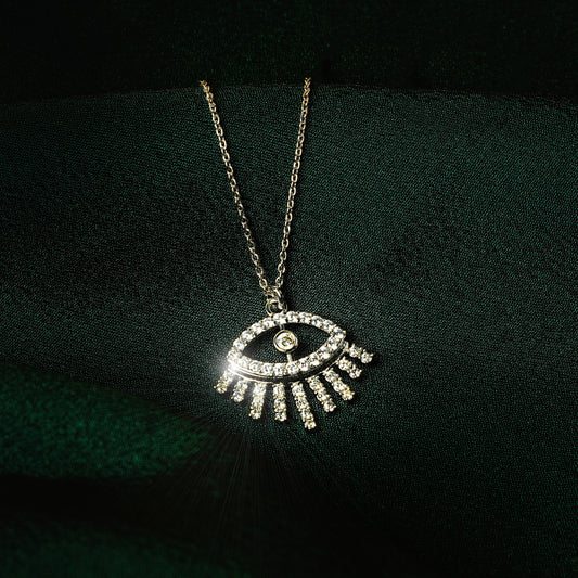 Silver eye pendant necklace for women with sparkling cubic zirconia stones in a minimalist modern design — demi-fine jewellery photographed on dark green satin