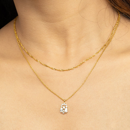 Close-up of Stellar Flow Pendant Set featuring a sparkling floral diamond cluster pendant paired with a delicate golden swirl chain, worn with an elegant off-shoulder black dress; a perfect blend of timeless sophistication and modern jewellery style for special occasions.
